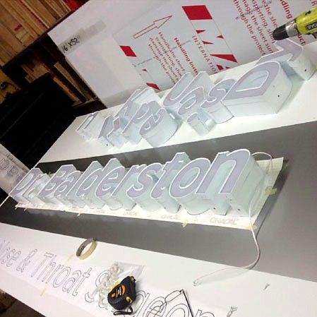 Channel letters being assembled on a shop table
