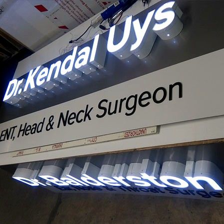 Illuminated channel letters for a medical office lit against a grey fascia